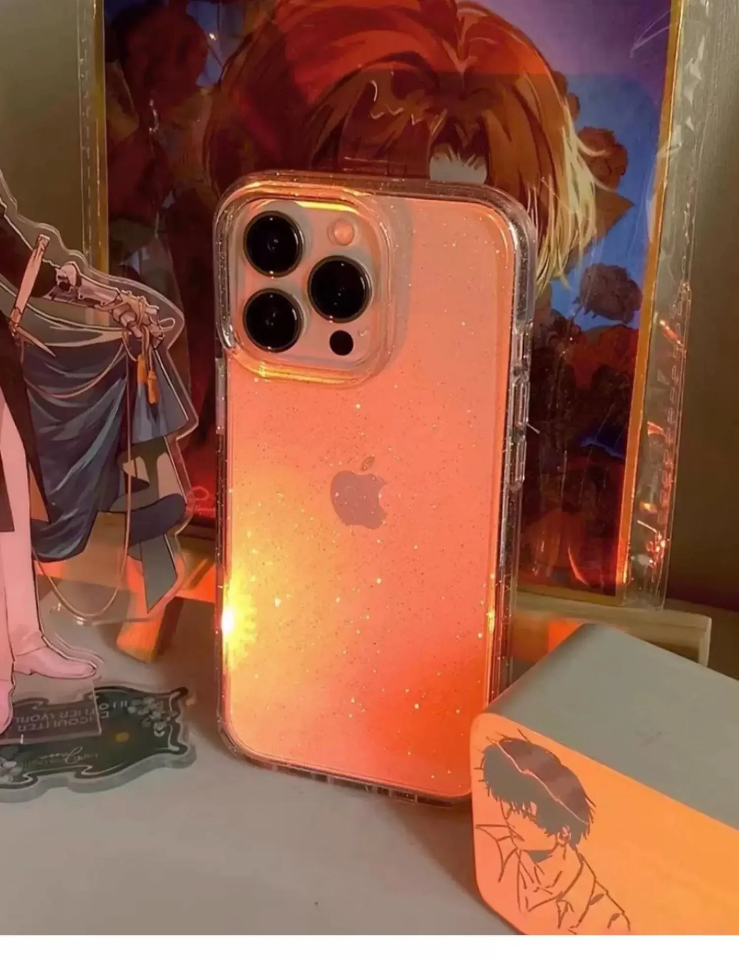Phone case with gradient design in front of anime-style illustrations