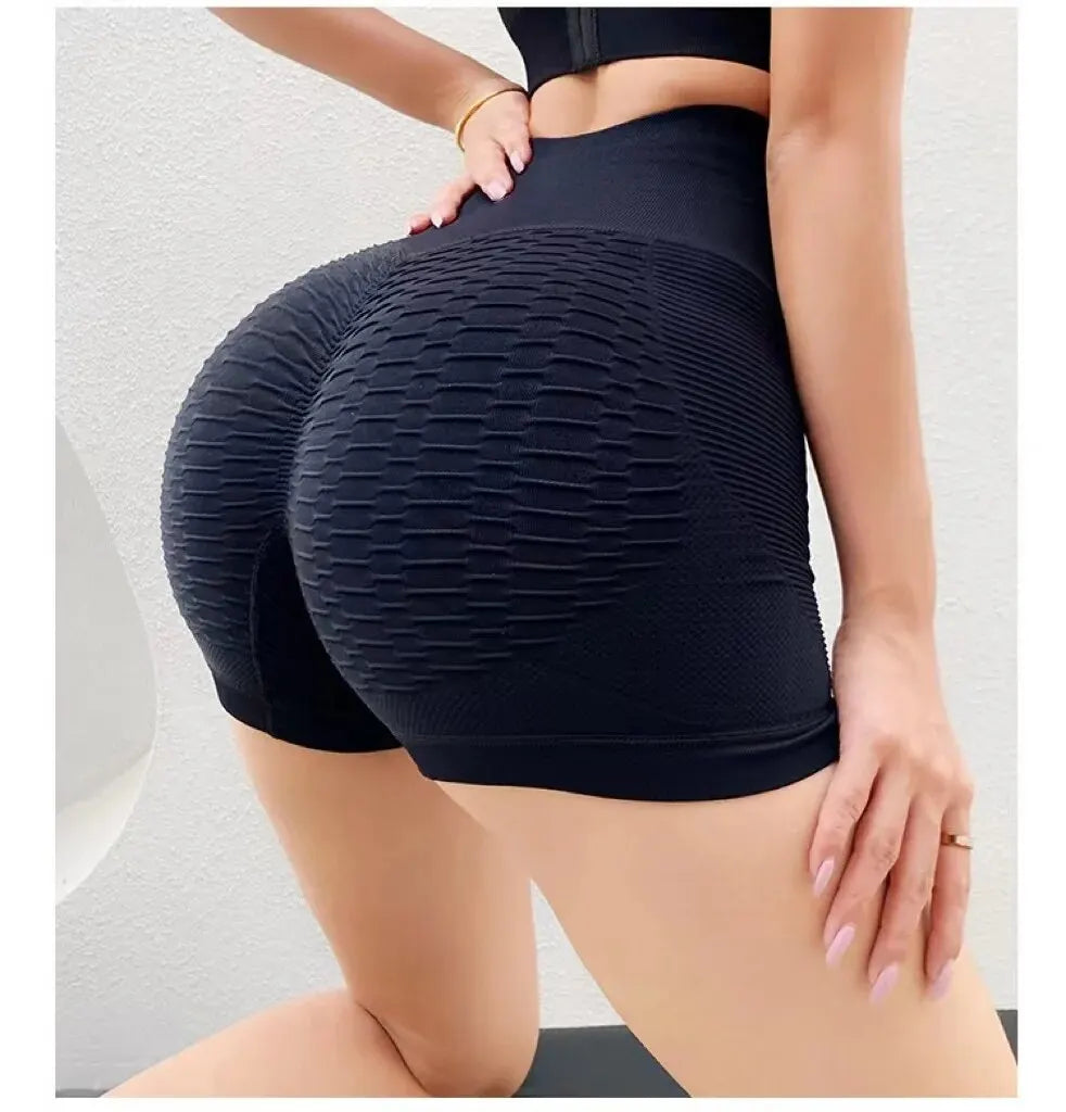 Person wearing a black textured skirt on a neutral background