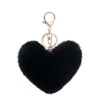 Black heart-shaped fluffy keychain with a gold chain on a white background