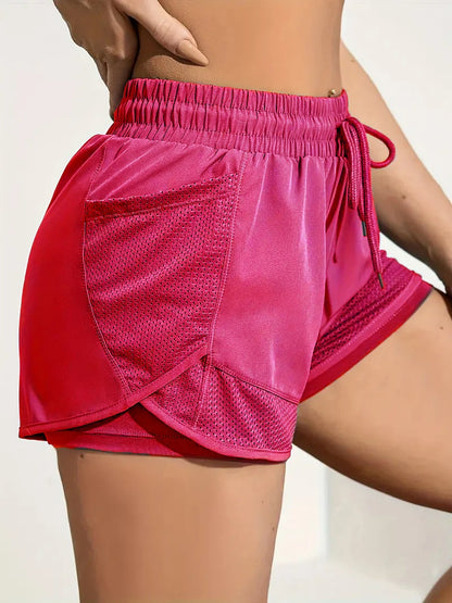 Pink athletic shorts worn by a person on a plain background