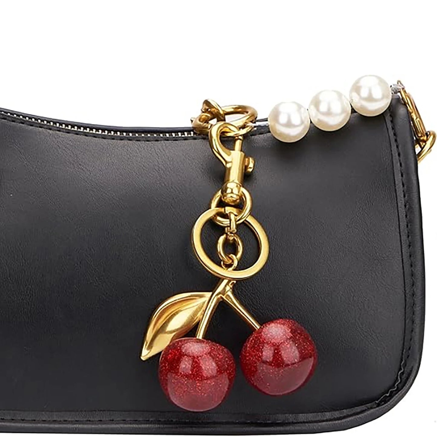 Black handbag with a cherry charm and pearl strap on a white background