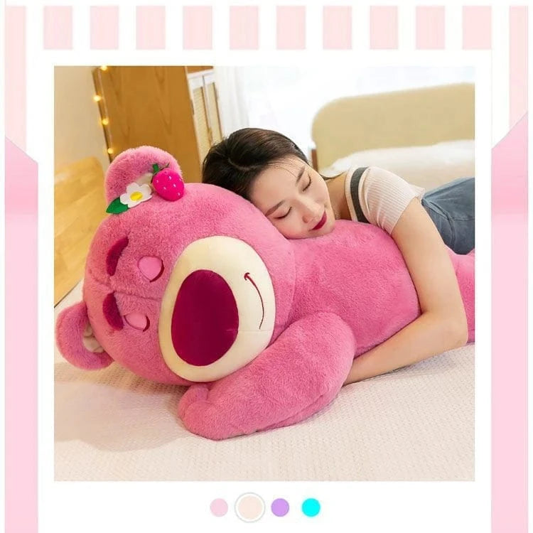 Person lying on a bed with a large pink plush toy resembling a cartoon character.