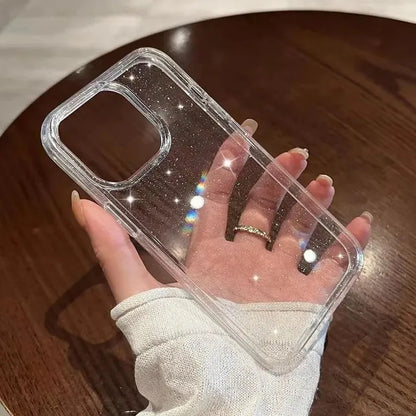 Clear phone case with glittery accents held by a hand on a wooden surface