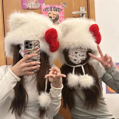 Two people wearing fluffy white hats with red accents, taking a selfie.