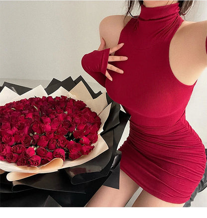 Person wearing a red dress with a large bouquet of red roses on a light gray background
