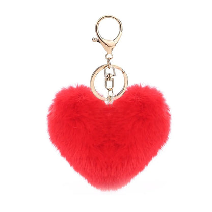 Red heart-shaped fluffy keychain with gold ring on a white background