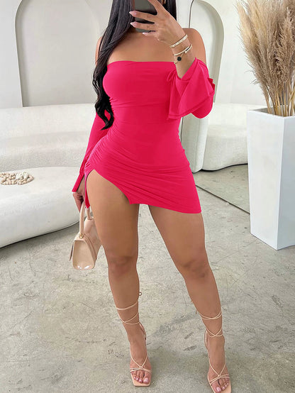 Woman in a bright pink off-shoulder dress taking a selfie in a modern interior setting.