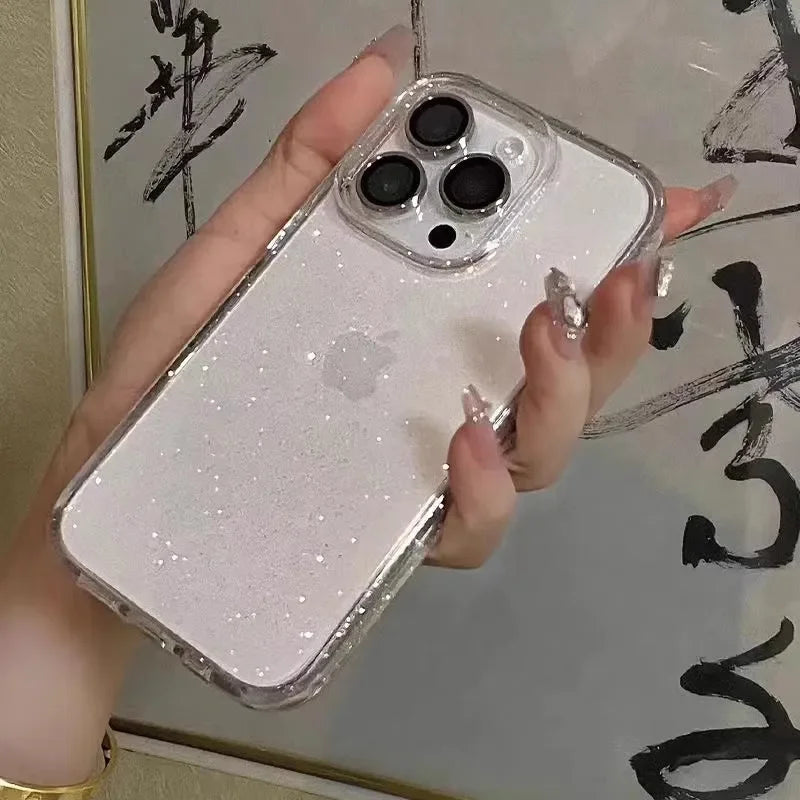 Hand holding a phone case with glittery finish against a decorative wall.