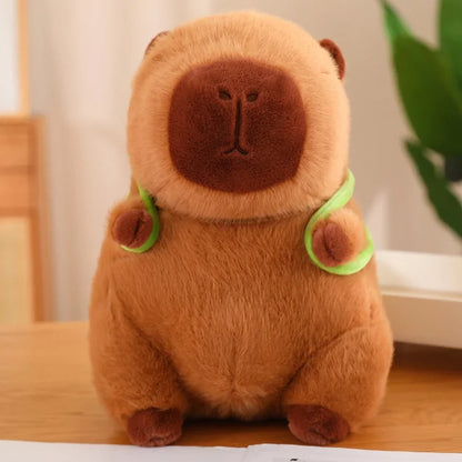 Brown teddy bear plush toy with green accents on a wooden surface.